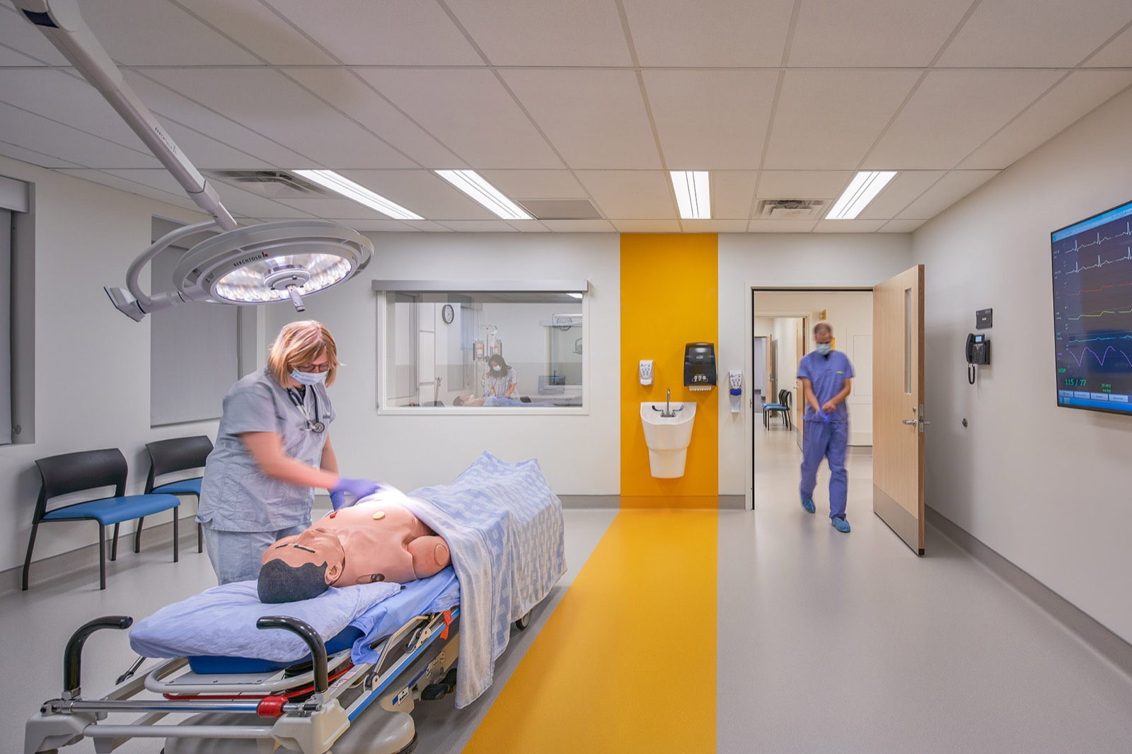 Clinician working with a patient simulator in a hospital simulation room